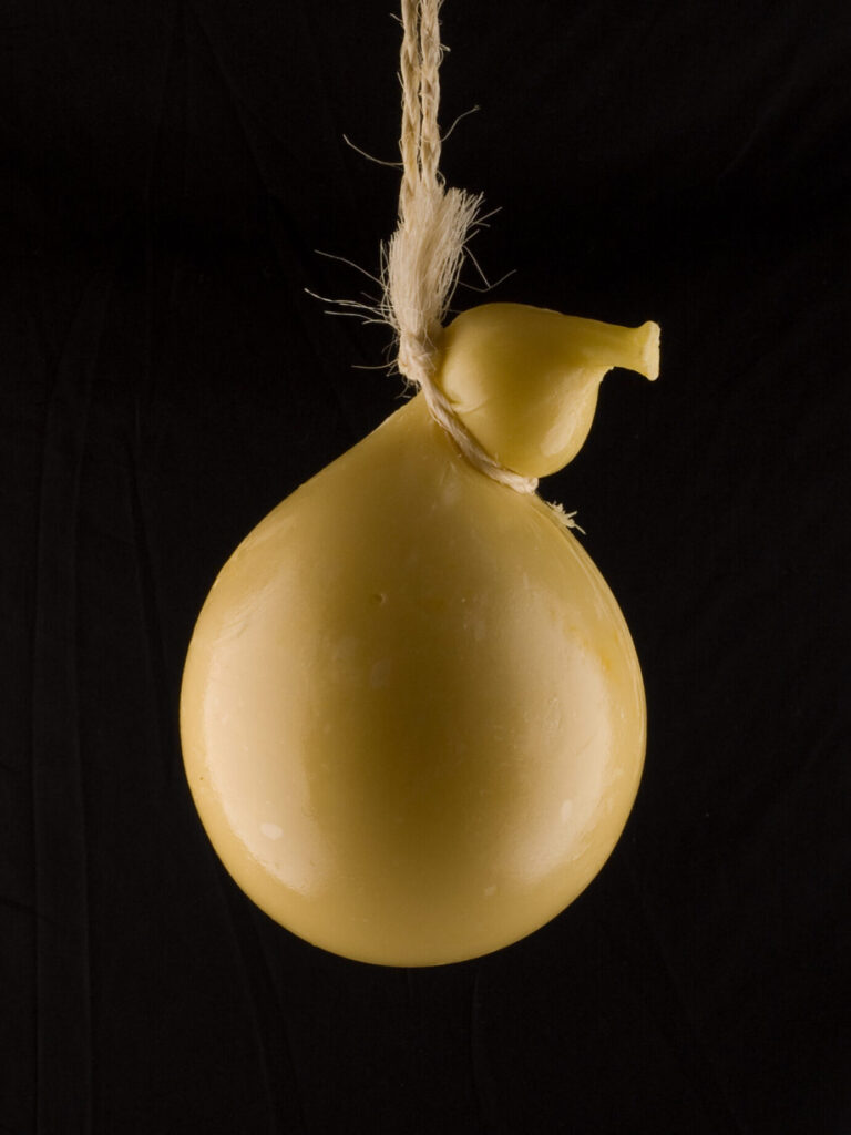 Caciocavallo cheese hung to dry. Photo via Adobe Stock.